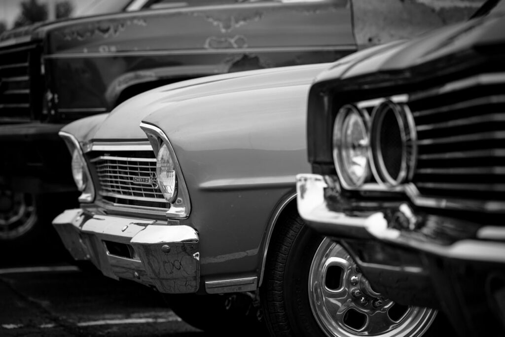 A stylish lineup of vintage classic cars in black and white, showcasing their timeless appeal.