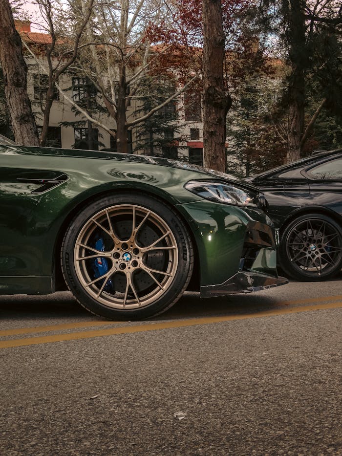 Side view of luxury sports cars parked on a tree-lined street in Ankara.